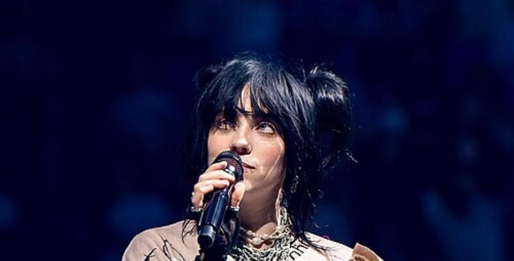 Billie Eilish performing on stage with a microphone