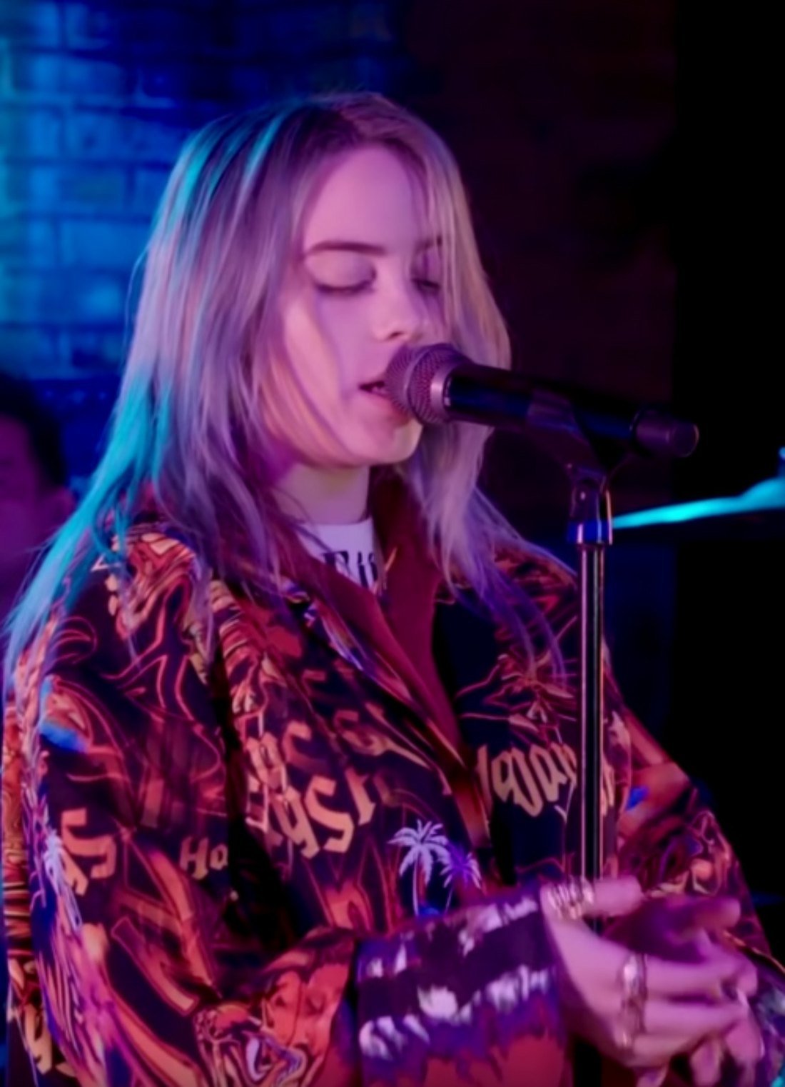 Billie Eilish singing at a microphone