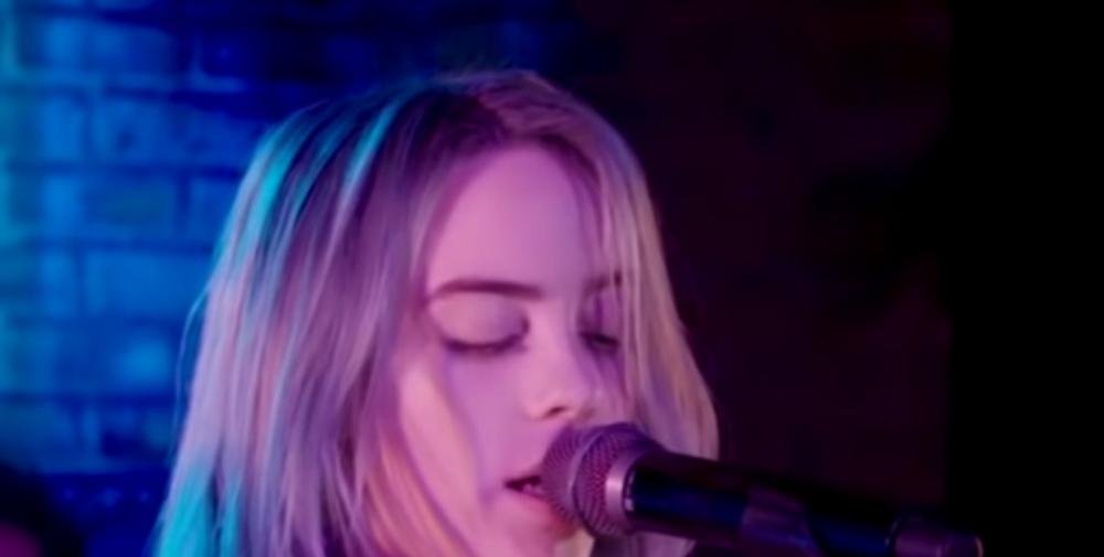 Billie Eilish singing at a microphone