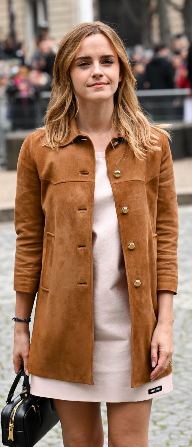 Emma Watson in a tan suede coat holding a black handbag