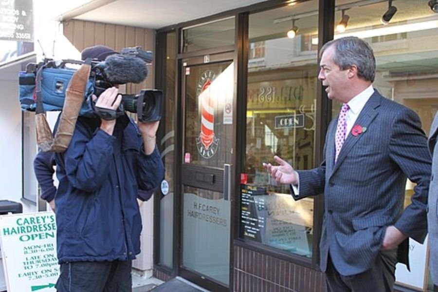 Camera crew filming a man outside a shop, used in the Brexit years section