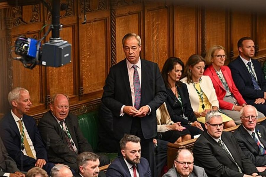 Man standing to speak in a parliamentary chamber, used in the career timeline section