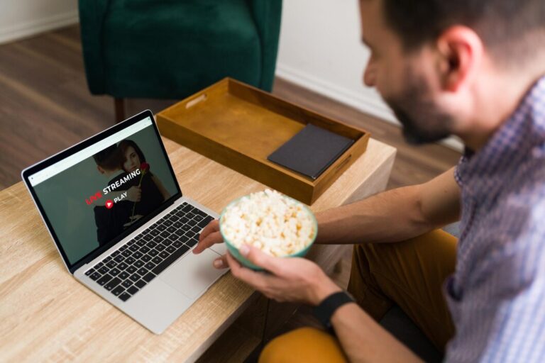 leisure-day-happy-man-searching-fun-movie-online-streaming-service-while-eating-popcorn_662251-2081